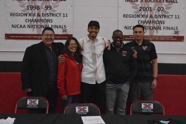 United Tribes Technical College's Rob McClain Jr., center, signed with NCAA Division I University of Texas Rio Grande Valley on Wednesday. Also photographed are from left, UTTC president Dr. Leander "Russ" McDonald, Karrie Lasley, McClain Jr.'s mother, Rob McClain Sr., and Pete Conway, head men's basketball coach at United Tribes.